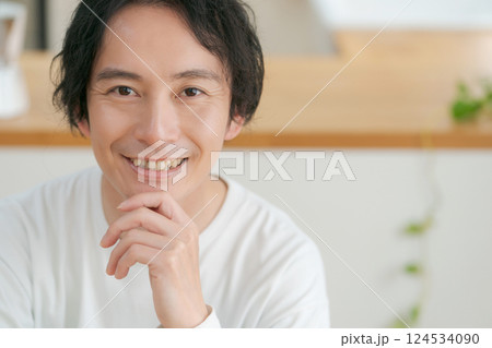 頬杖をつく笑顔の男性 124534090