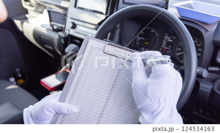 タクシー日報を書くタクシードライバー　顔なし　手元 124534163