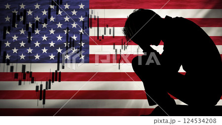 A silhouette of a man standing in front of a declining economic chart, symbolizing the USA unemployment crisis during a recession. The American flag is in the background 124534208