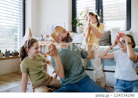 Portrait of father with three daughters at home. 124534290