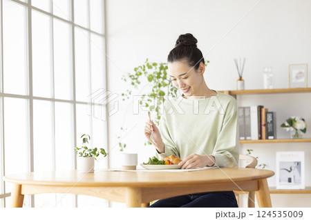 自宅で食事をとる女性 124535009