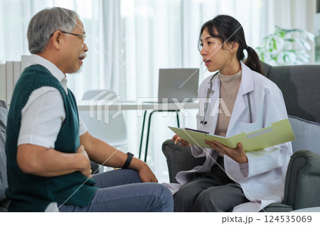 Doctor Talking to Senior Patient with Stomach Pain During Health Consultation 124535069