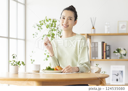 自宅で食事をとる女性 自宅で食事をとる女性 124535080