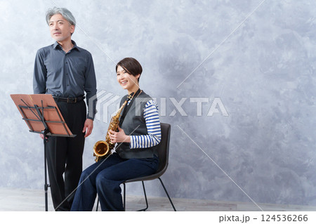 レッスンする大人の音楽教室の先生とサックスを教わる生徒 124536266