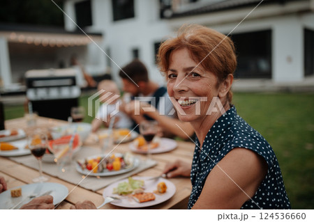 Portrait of beautiful older woman during family barbecue. Portrait of beautiful older woman during family barbecue. 124536660