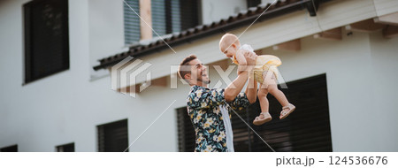 Happy father playing with his baby daughter in the backyard. Happy father playing with his baby daughter in the backyard. 124536676