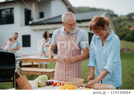 Older married couple preparing food for a family barbecue. 124536684
