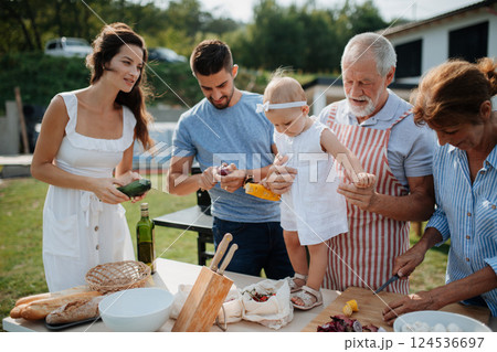 Three generations of family preparing food for a spring weekend barbecue. 124536697