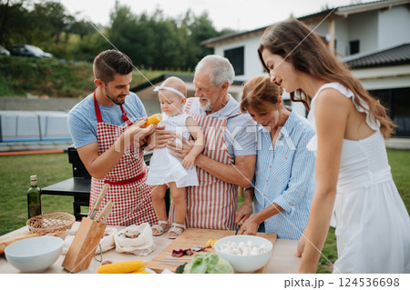 Three generations of family preparing food for a spring weekend barbecue. 124536698