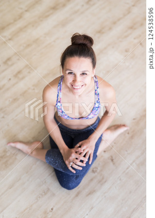 Cheerful fit sporty active girl in fashion sportswear sitting on the floor in yoga studio. Active urban lifestyle. 124538596