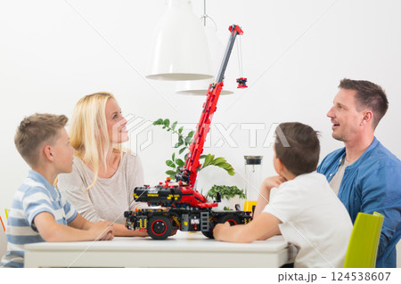Happy young family playing with toys at dining table at bright modern home. Spending quality leisure time with children and family concept. 124538607