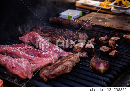 Some excellent pieces of Argentinian beef on a charcoal grill being prepared at open kitchen street food festival in Ljubljana, Slovenia 124538822