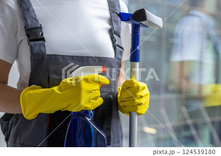 Female cleaner standing with the window washer in her hands Female cleaner standing with the window washer in her hands 124539180