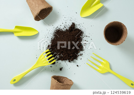 Various gardening hand green tools, flower pot and soil on blue background. Spring gardening. Concept season work and hobby. Copy space. Top view. Various gardening hand green tools, flower pot and soil on blue background. Spring gardening. Concept season work and hobby. Copy space. Top view. 124539619