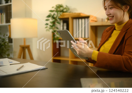 Smiling young creative woman using stylus writing on digital tablet 124540222