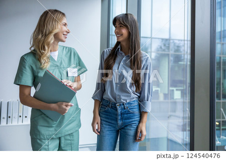 Male specialist holding file and documents discussing treatment with woman patient 124540476