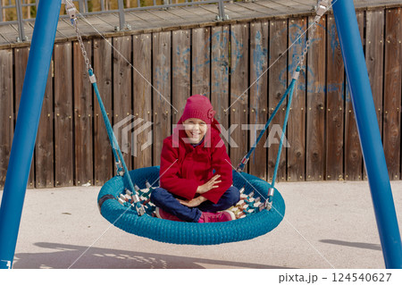 Caucasian smiling child of 8 9 years swinging on round seesaw Caucasian smiling child of 8 9 years swinging on round seesaw 124540627