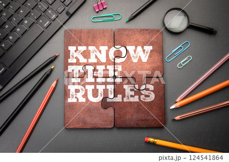 Know The Rules. Wooden puzzle pieces with text on a dark office table 124541864