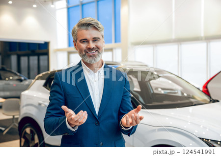 Manager working with a buyer in the showroom showing available cars Manager working with a buyer in the showroom showing available cars 124541991