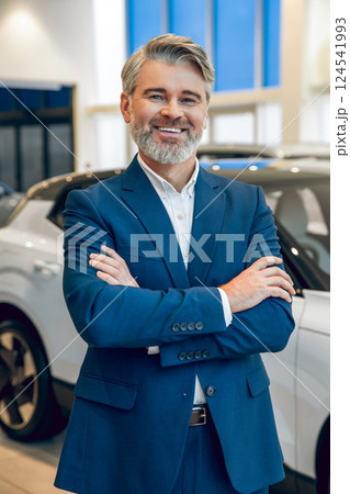 Manager working with a buyer in the showroom showing available cars 124541993