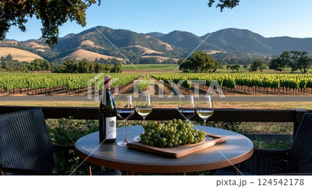 Intimate table for two surrounded by vineyards, showcasing fresh grapes, wine, and a breathtaking view of the mountains 124542178