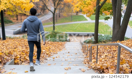 Feet in jeans and shoes traverse wooden stairs amidst autumn foliage in a serene park, enjoying a daytime walk in nature 124542179
