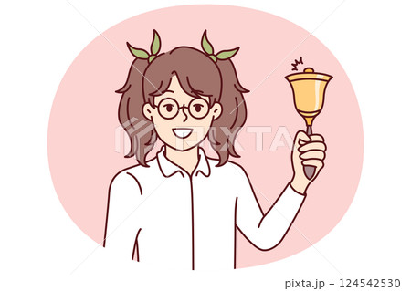 Elementary school girl holds bell for start of academic year and looks at screen smiling 124542530