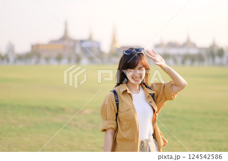 A Traveler Asian woman in her 30s exploring Wat Pra Kaew. From stunning architecture to friendly locals, she cherishes every moment, capturing it all in her heart and camera for years to come. 124542586