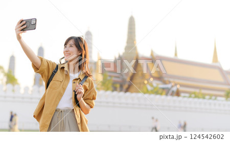 Traveler asian woman in her 30s explores the Grand Palace with a local guide. Uncover hidden gems and immerse yourself in Thai culture with her adventure. 124542602