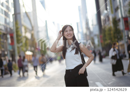 Embrace the urban vibe as a young Asian woman showcases a blend of style, confidence, and a carefree spirit on her city stroll. Embrace the urban vibe as a young Asian woman showcases a blend of style, confidence, and a carefree spirit on her city stroll. 124542629