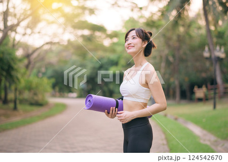 pretty fitness yoga woman in the park with yoga mat 124542670