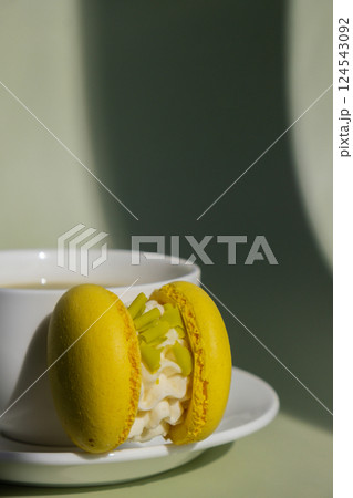 Green latte matcha with yellow macaron dessert on pastel background with creative deep shadows. Concept of holiday breakfast morning tea drink. Cozy minimalist superfood vibrant colors healthy eating 124543092