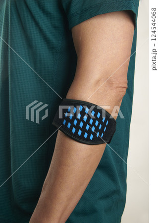 athlete man wears an epicondylitis bracelet 124544068