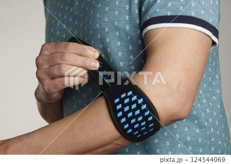 man adjusting his epicondylitis bracelet man adjusting his epicondylitis bracelet 124544069