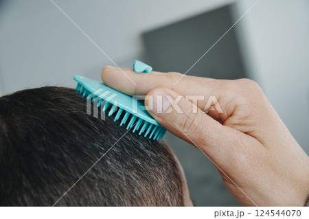 man in the bathroom combing his hair 124544070