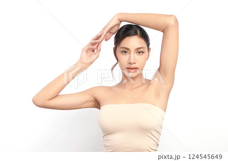 Beautiful Young Asian woman Raises her hands to Showcase clean and hygienic underarms Against a white background, Smooth armpit cleanliness and protection concept 124545649