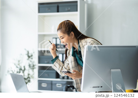 Happy nusinesswoman holding a smartphone and laptop, happy smiling, getting bonus money. Happy nusinesswoman holding a smartphone and laptop, happy smiling, getting bonus money. 124546132