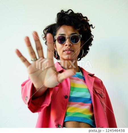 Hispanic young female with sunglasses and outstretched hand in colorful outfit 124546438