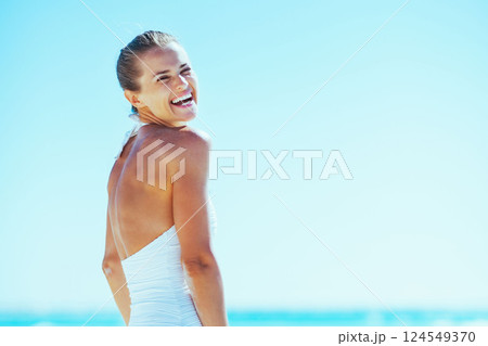smiling young woman on sea shore 124549370