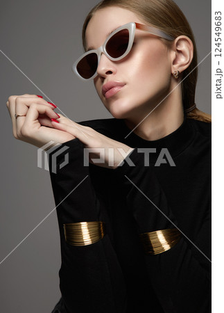 Beautiful young woman in sunglasses. blond girl in glasses and bracelets Beautiful young woman in sunglasses. blond girl in glasses and bracelets 124549683