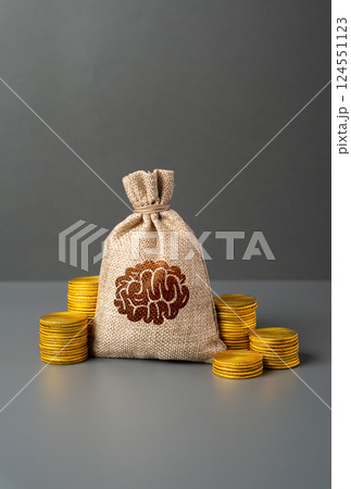 A bag with a brain symbol and money coins. Hunt for best minds and competition between leading powers for skilled specialists professionals. Attract top talent in science, technology, and innovation. 124551123
