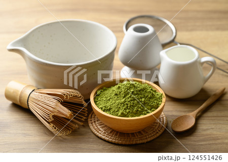Matcha green tea powder with tea bowl and chasen on wooden background Matcha green tea powder with tea bowl and chasen on wooden background 124551426