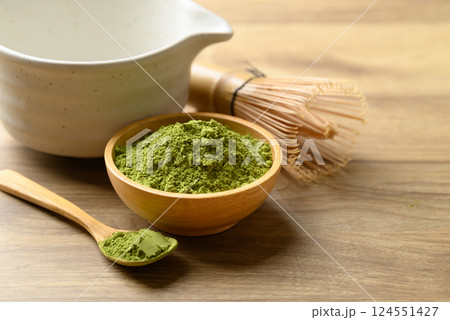 Matcha green tea powder with tea bowl and chasen on wooden background Matcha green tea powder with tea bowl and chasen on wooden background 124551427
