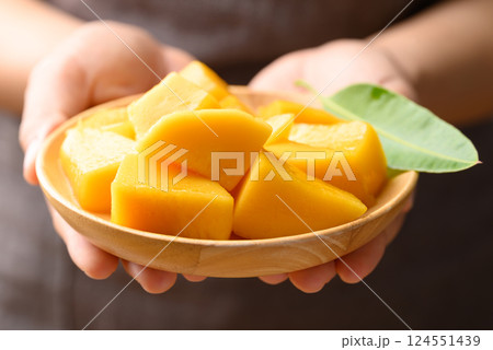 Cube mango on wooden plate holding by hand ready to eating, Tropical fruit in summer season 124551439