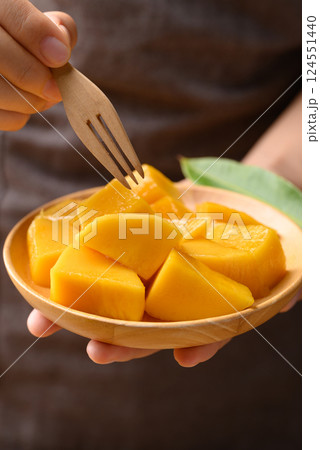Cube mango on wooden plate holding by hand ready to eating, Tropical fruit in summer season 124551440
