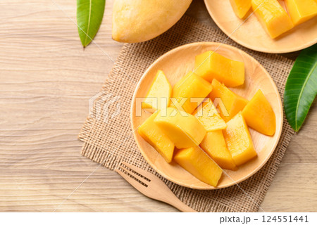 Cube mango on wooden plate ready to eating, Tropical fruit in summer season, Table top view 124551441