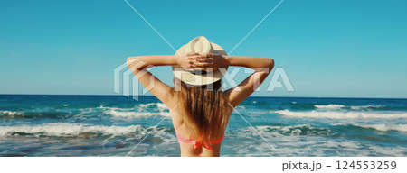 Summer vacation, relaxed beautiful young woman in swimsuit, tourist hat on the beach on sea coast Summer vacation, relaxed beautiful young woman in swimsuit, tourist hat on the beach on sea coast 124553259