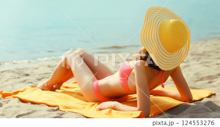 Summer vacation, beautiful happy relaxing young woman with tourist hat lying on the beach at sea Summer vacation, beautiful happy relaxing young woman with tourist hat lying on the beach at sea 124553276