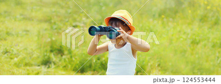Little boy child looking through binoculars outdoors on summer day Little boy child looking through binoculars outdoors on summer day 124553444