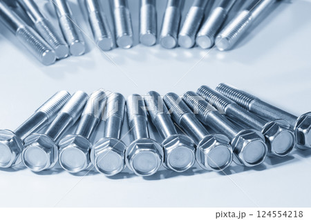Close up scene the group of bolts with hexagon head with thread for use with nuts in the light blue scene. 124554218